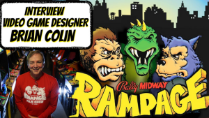 Interview with video game designer Brian Colin, shown smiling in a Rampage arcade wearing a red shirt, alongside the colorful title art from Bally Midway's Rampage featuring cartoon monsters George, Lizzie, and Ralph against a city skyline.